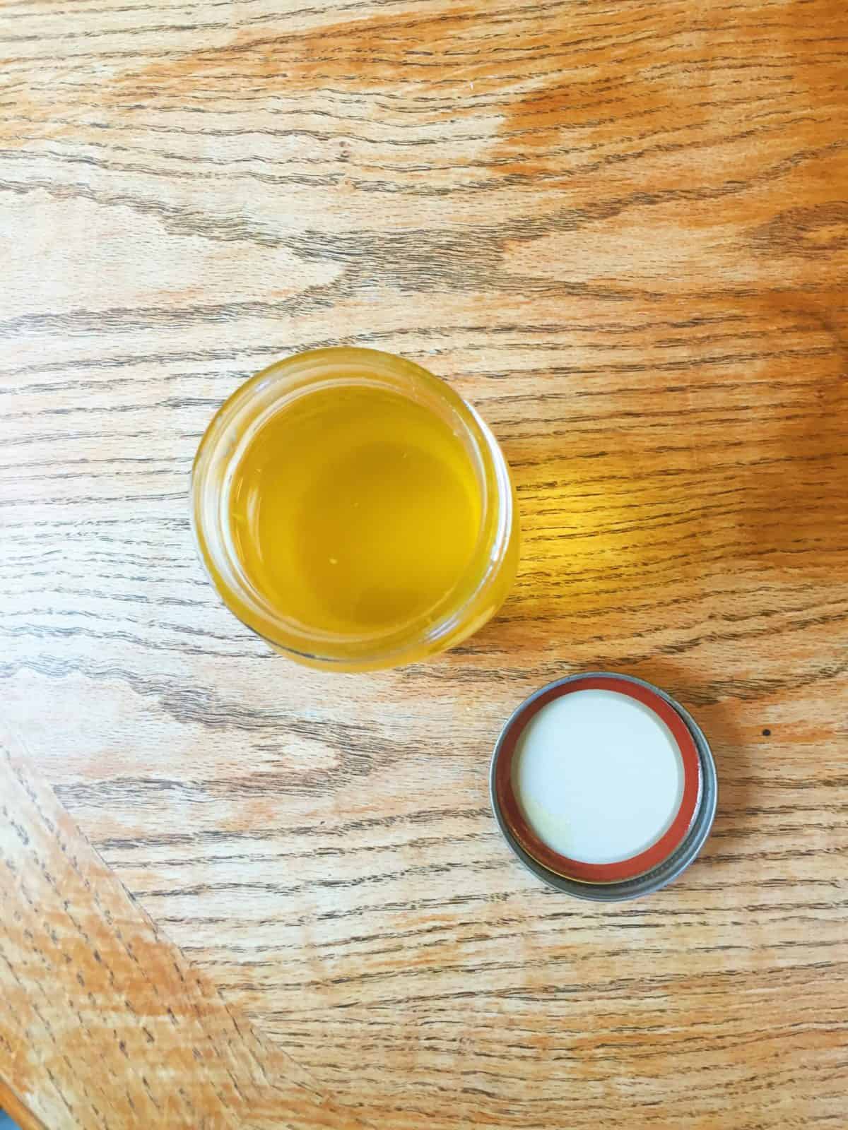 Overhead view of ghee in a mason jar on a table.