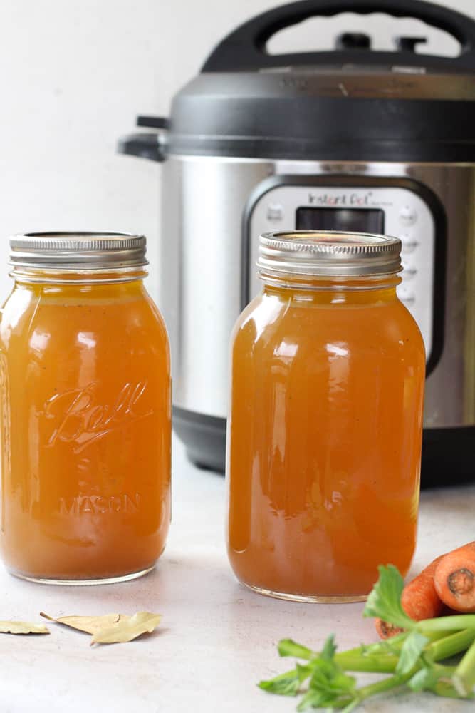 Side view of chicken broth in mason jars.