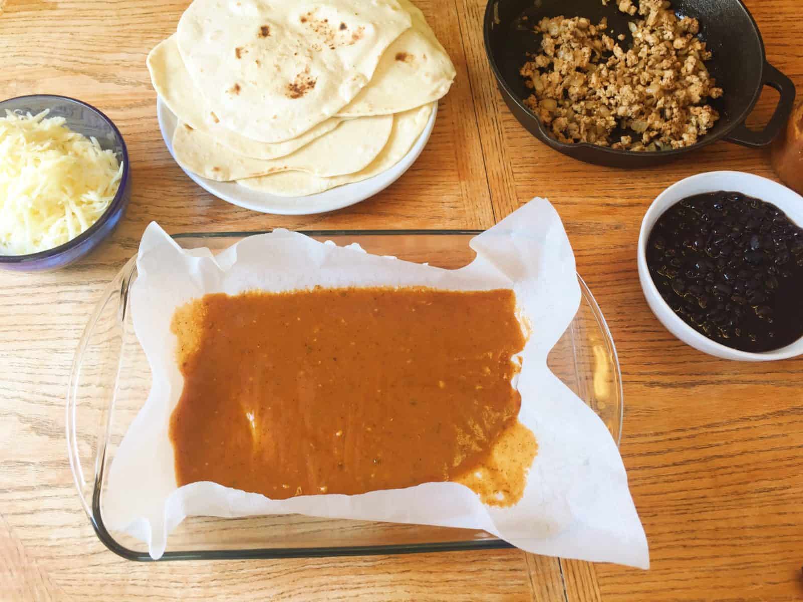 Enchilada sauce in a baking dish.