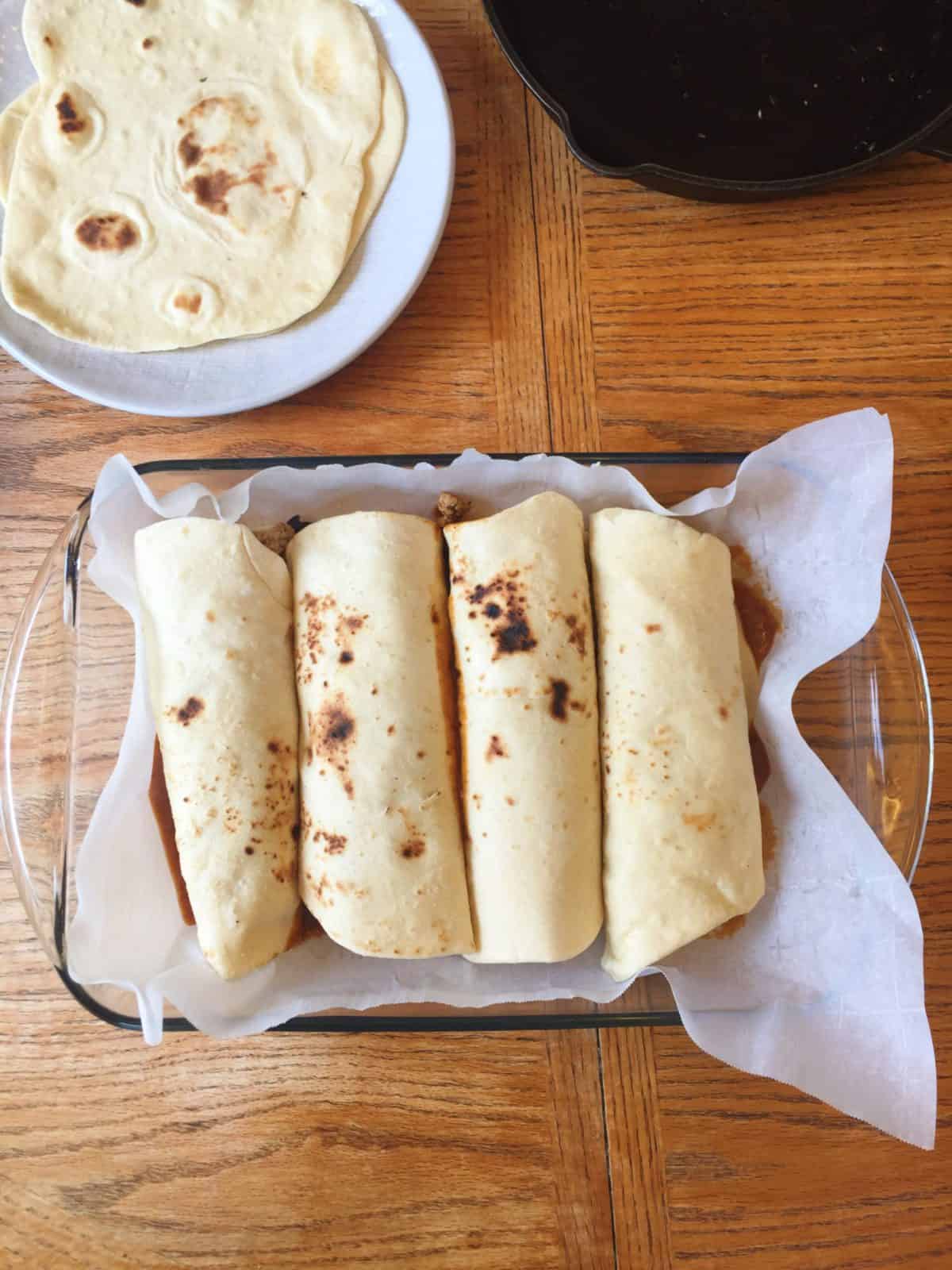Rolled and stuffed enchiladas in a baking dish.