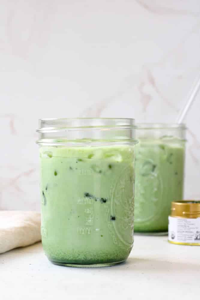 Matcha tea and milk and ice in a mason jar