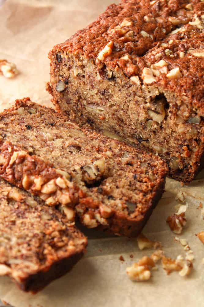 Sliced banana nut bread on parchment paper.