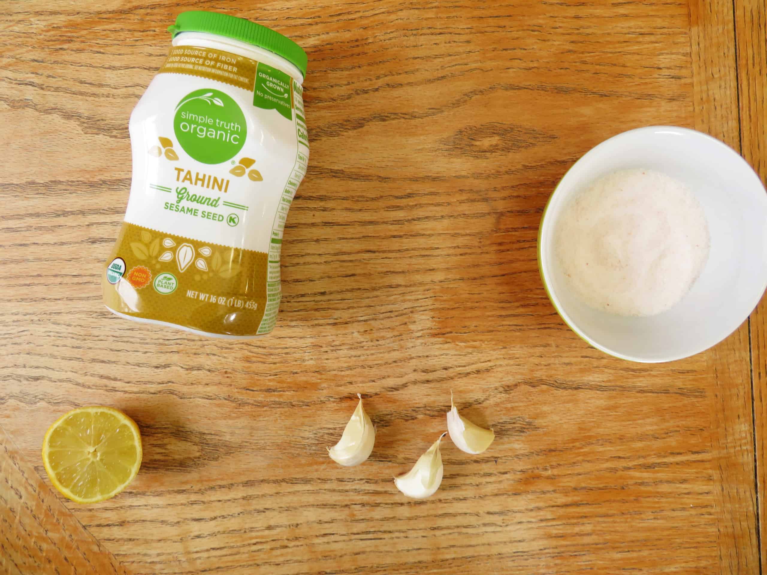 Lemon garlic tahini salad dressing ingredients on a table.