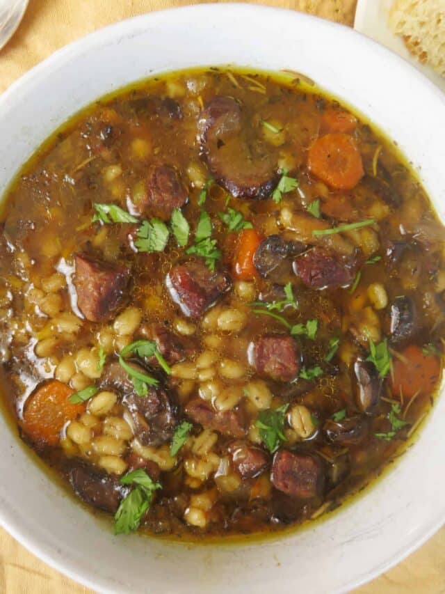 Overhead image of beef and barley soup in a bowl.