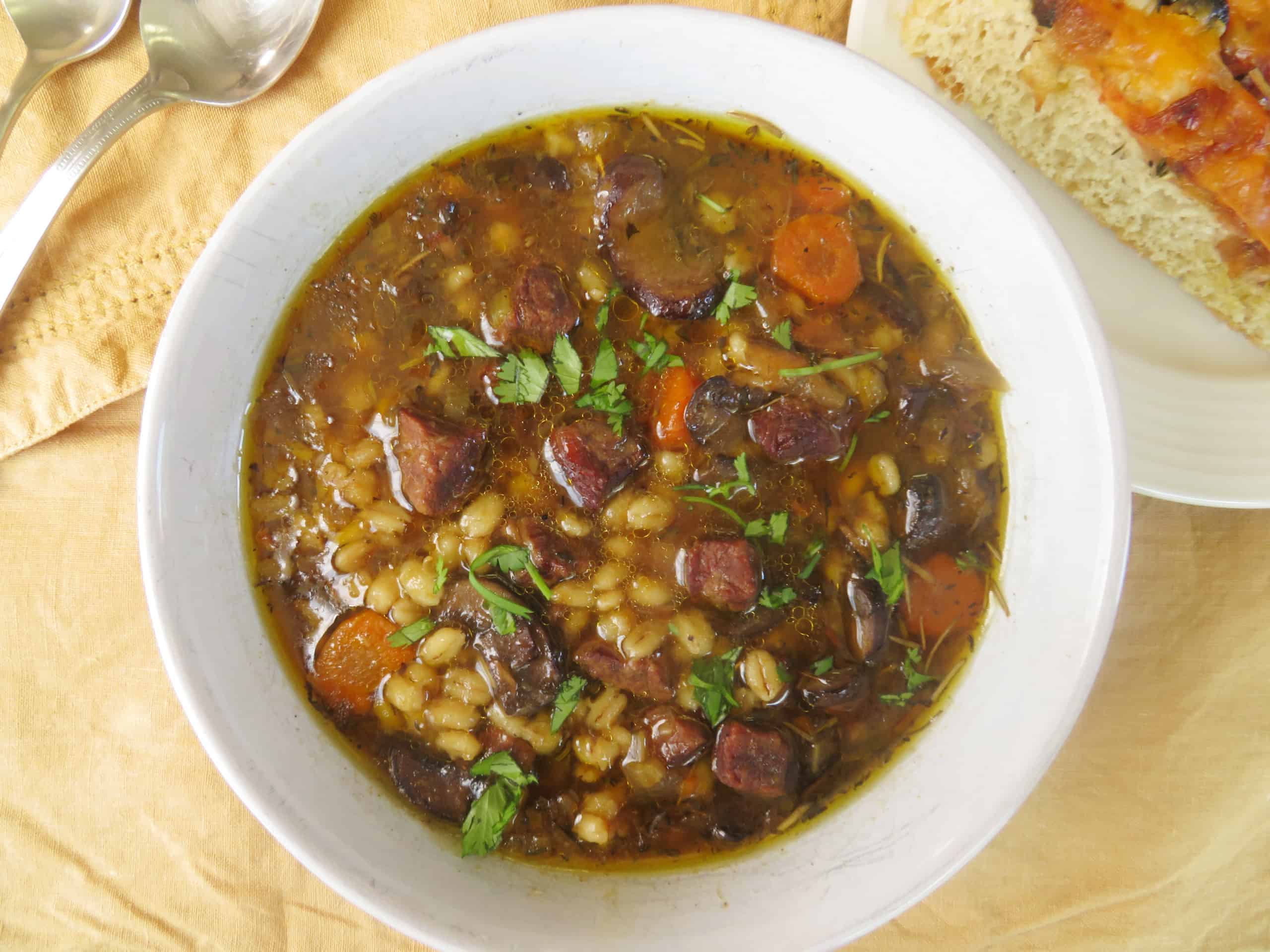 Overhead image of beef and barley soup in a bowl.