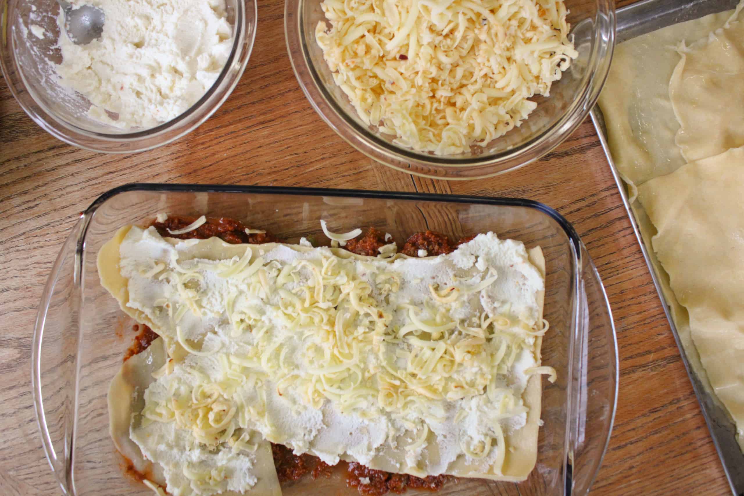 How to layer lasagna. Process image of lasagna being layered before baking.