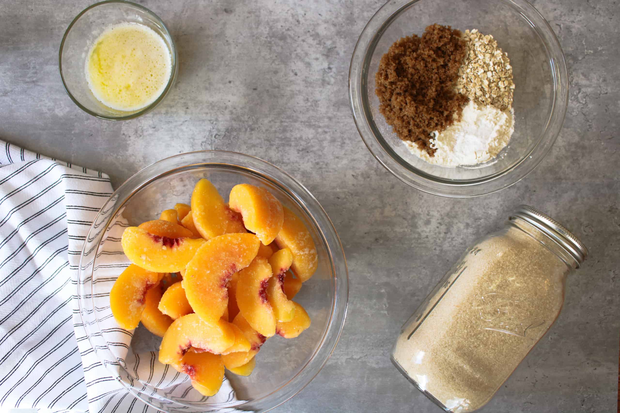 Ingredients for peach dessert on a table in bowls. 
