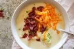 slow cooker loaded baked potato soup in a bowl on a table