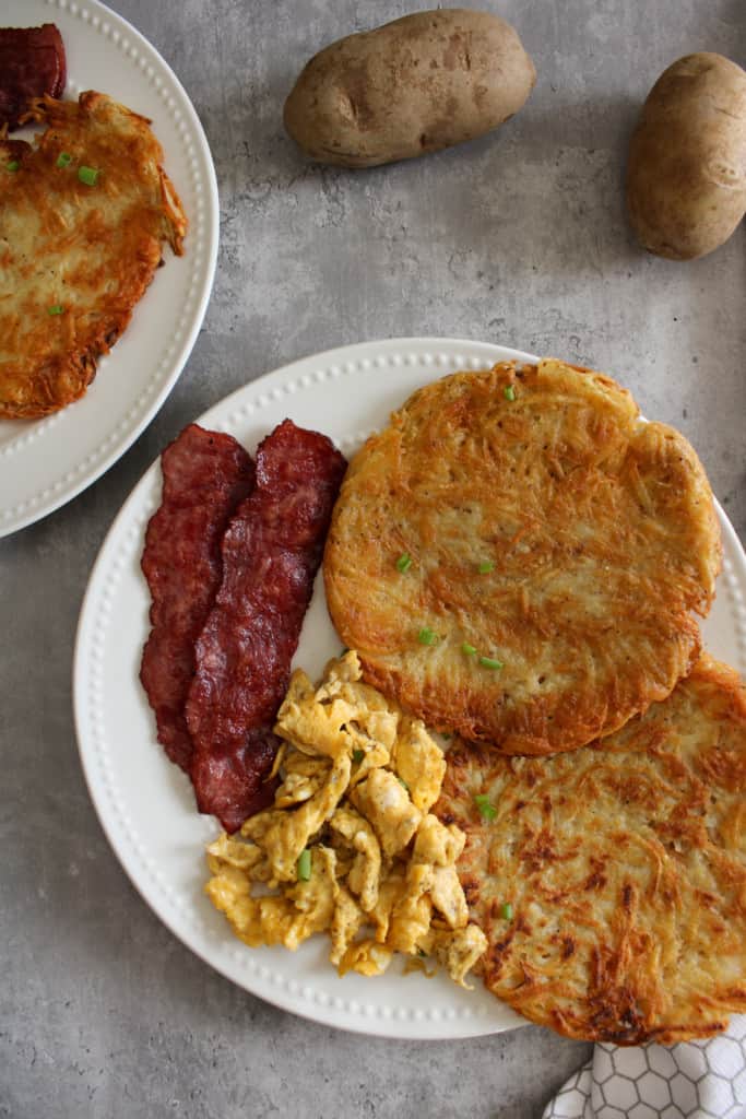 top view of breakfast potatoes with eggs and bacon on a plate