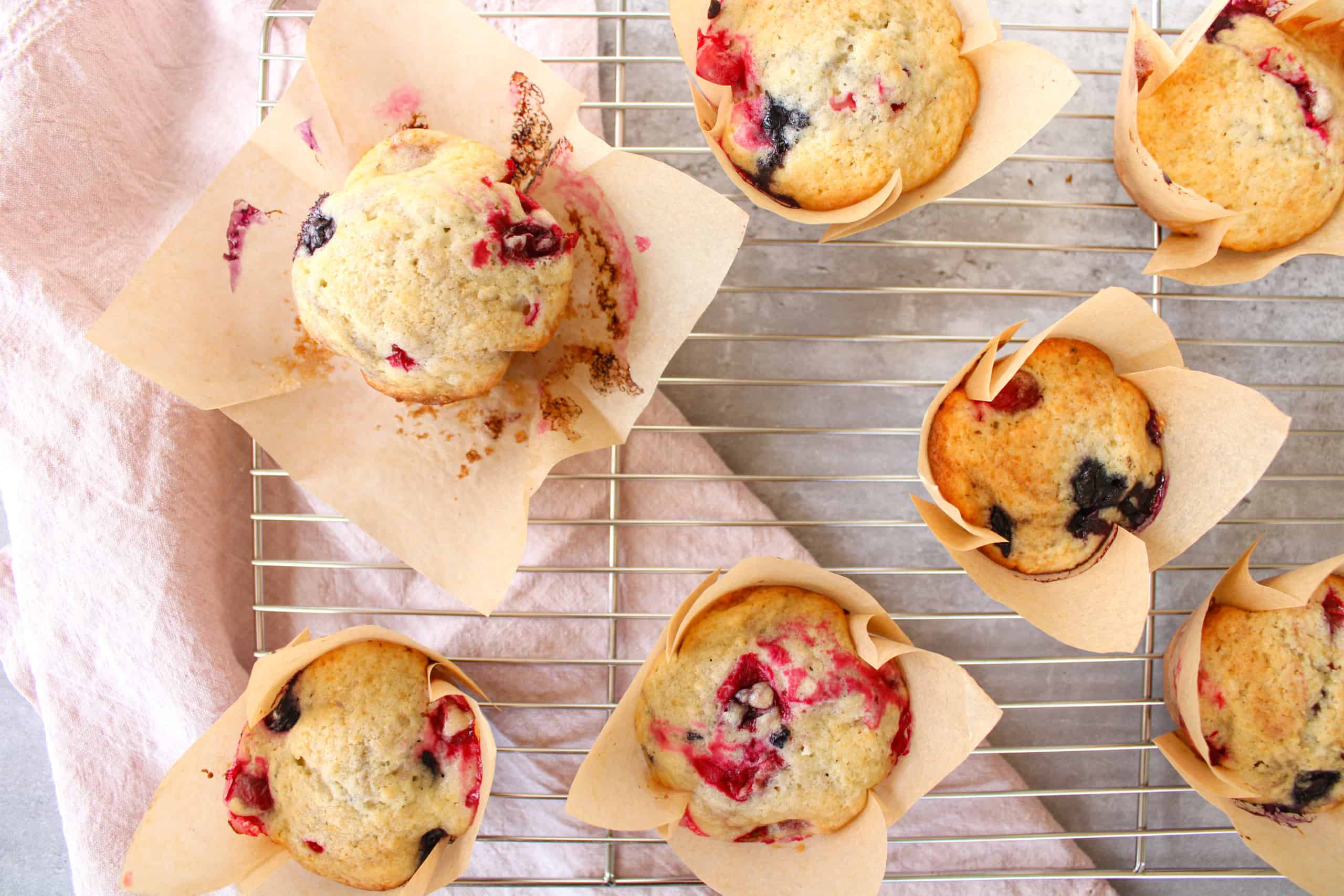 Close up on easy jumbo blueberry cranberry muffins on a wire rack.