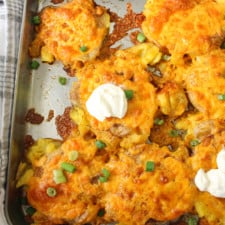 over head of paprika seasoned smashed potatoes on a sheet pan