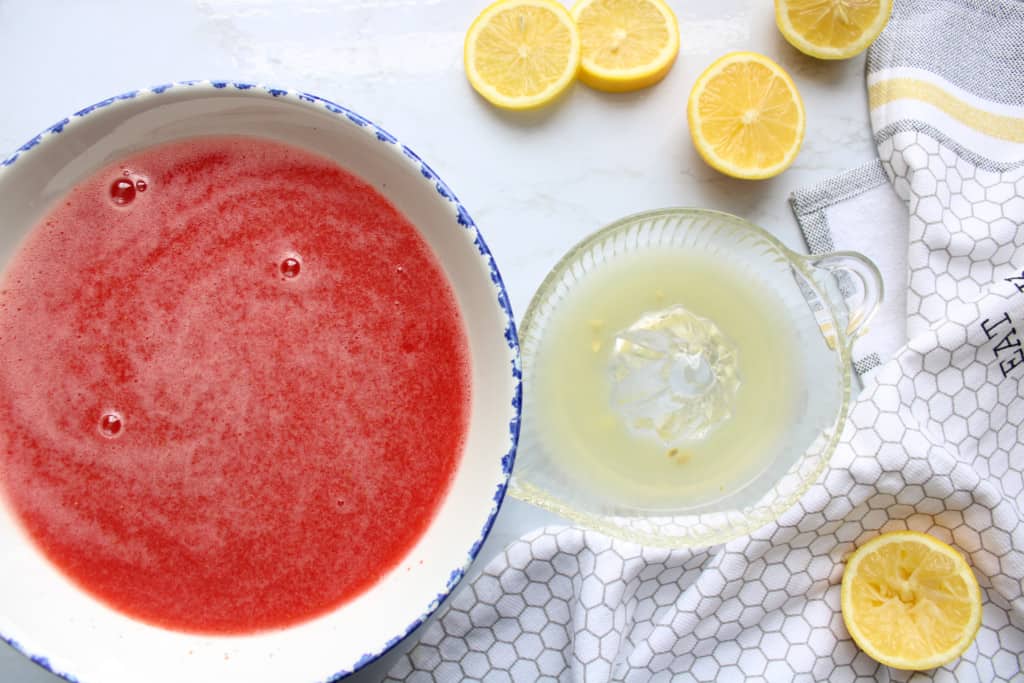 top view of blended strawberries and lemon juice in a juicer on a table