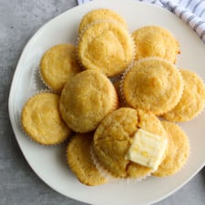 Top view of cornbread muffins on a table with honey and butter