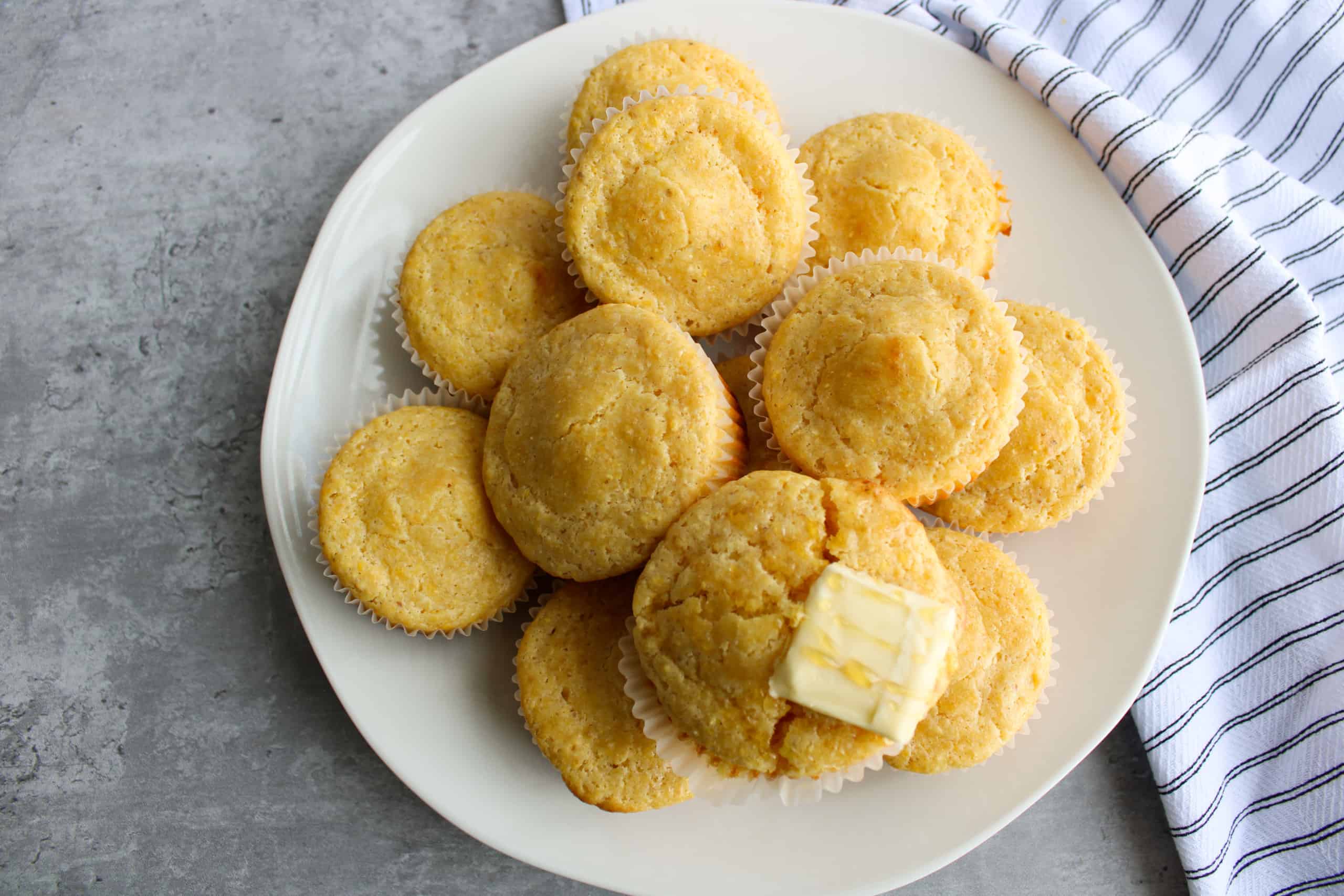 Top view of cornbread muffins on a table with honey and butter