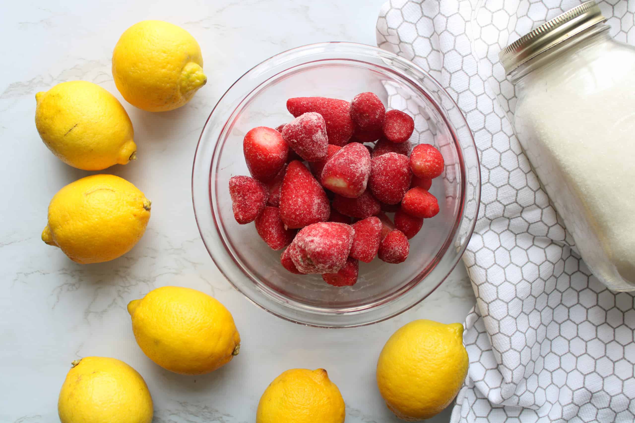 Overhead view of strawberry lemonade ingredients on a table