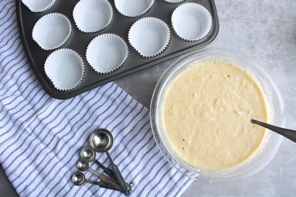 Cornbread muffins batter and muffins pan on a table