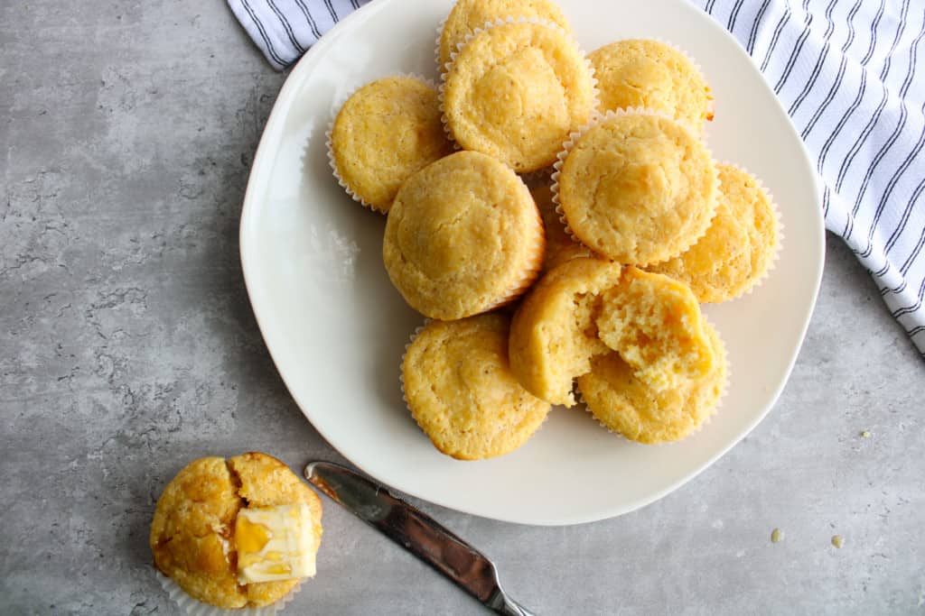 Muffins on a plate with butter and a butter knife