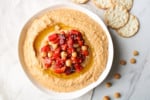 Close up on garlic and roasted pepper hummus in a bowl.