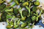 Close up of oven roasted broccoli in a sheet pan.