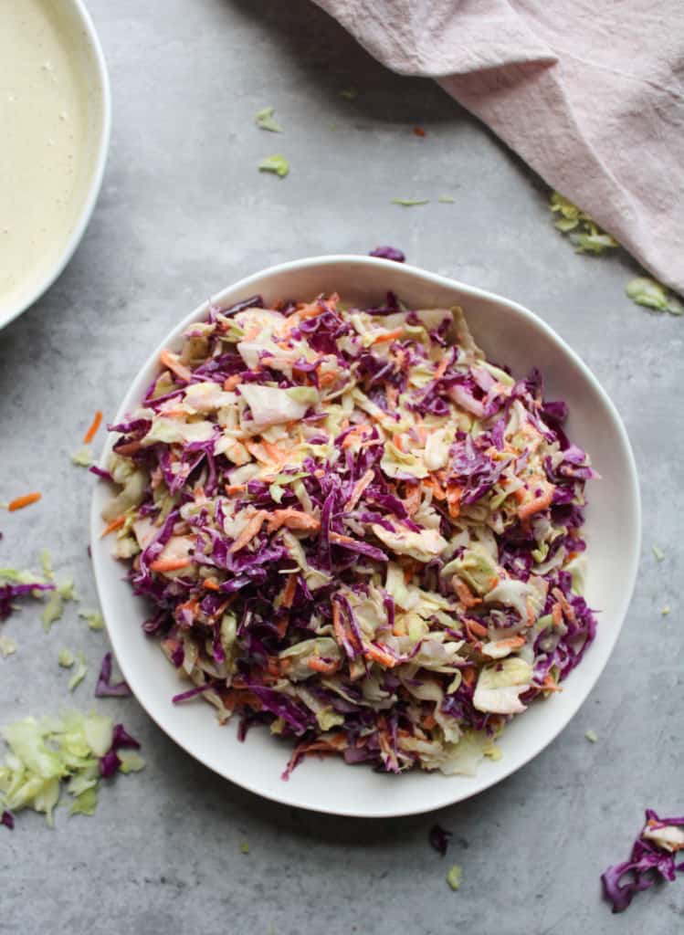 Easy purple coleslaw in a bowl on a table. 