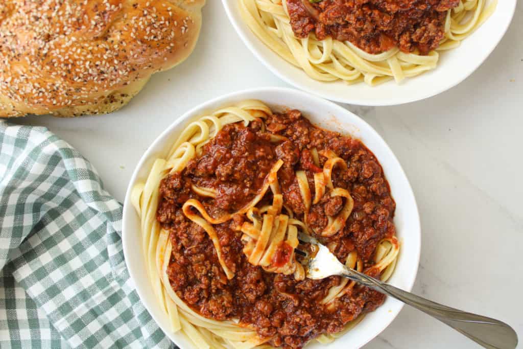 Meat sauce over pasta with a fork. 