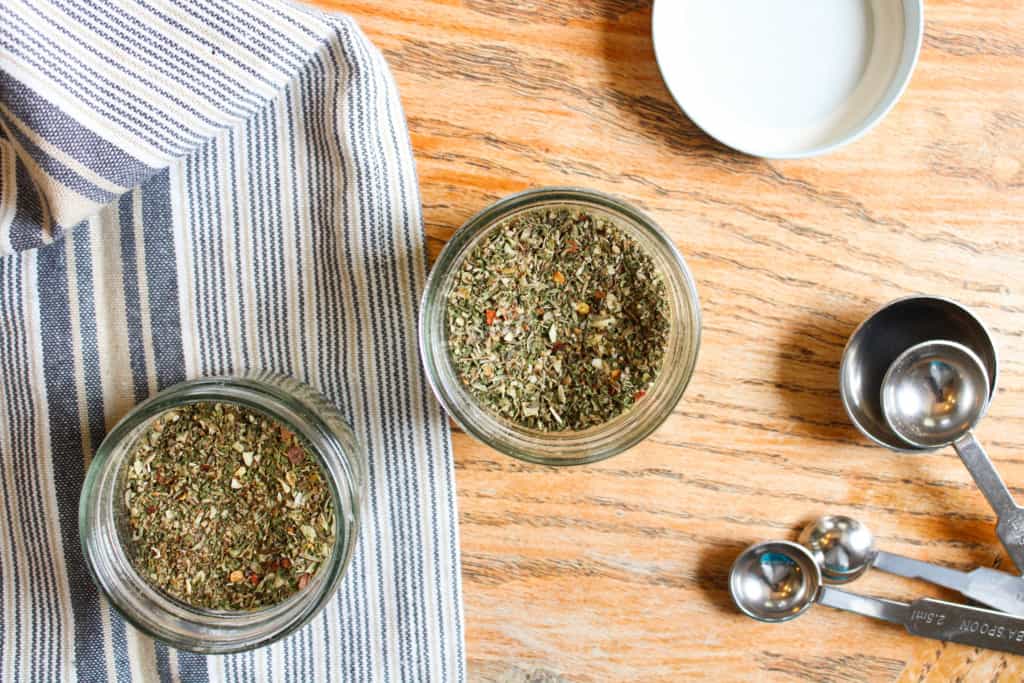 Overhead view of homemade sausage seasoning in jars. 