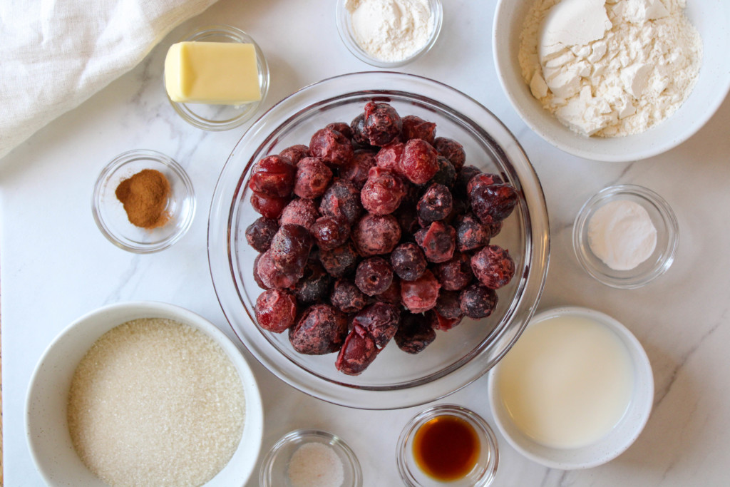Overhead of cherry cobbler ingredients on a table.