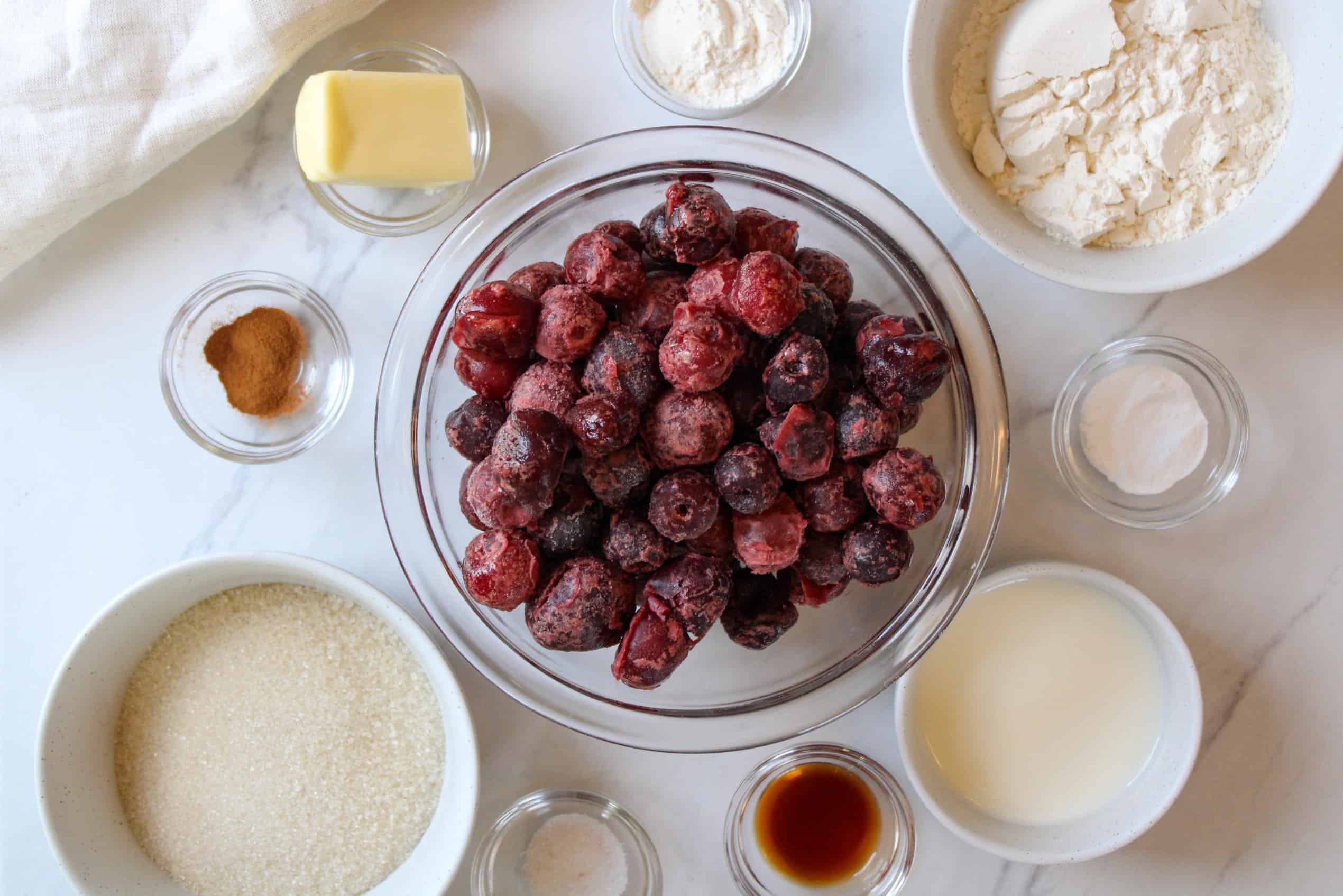Overhead of cherry cobbler ingredients on a table.