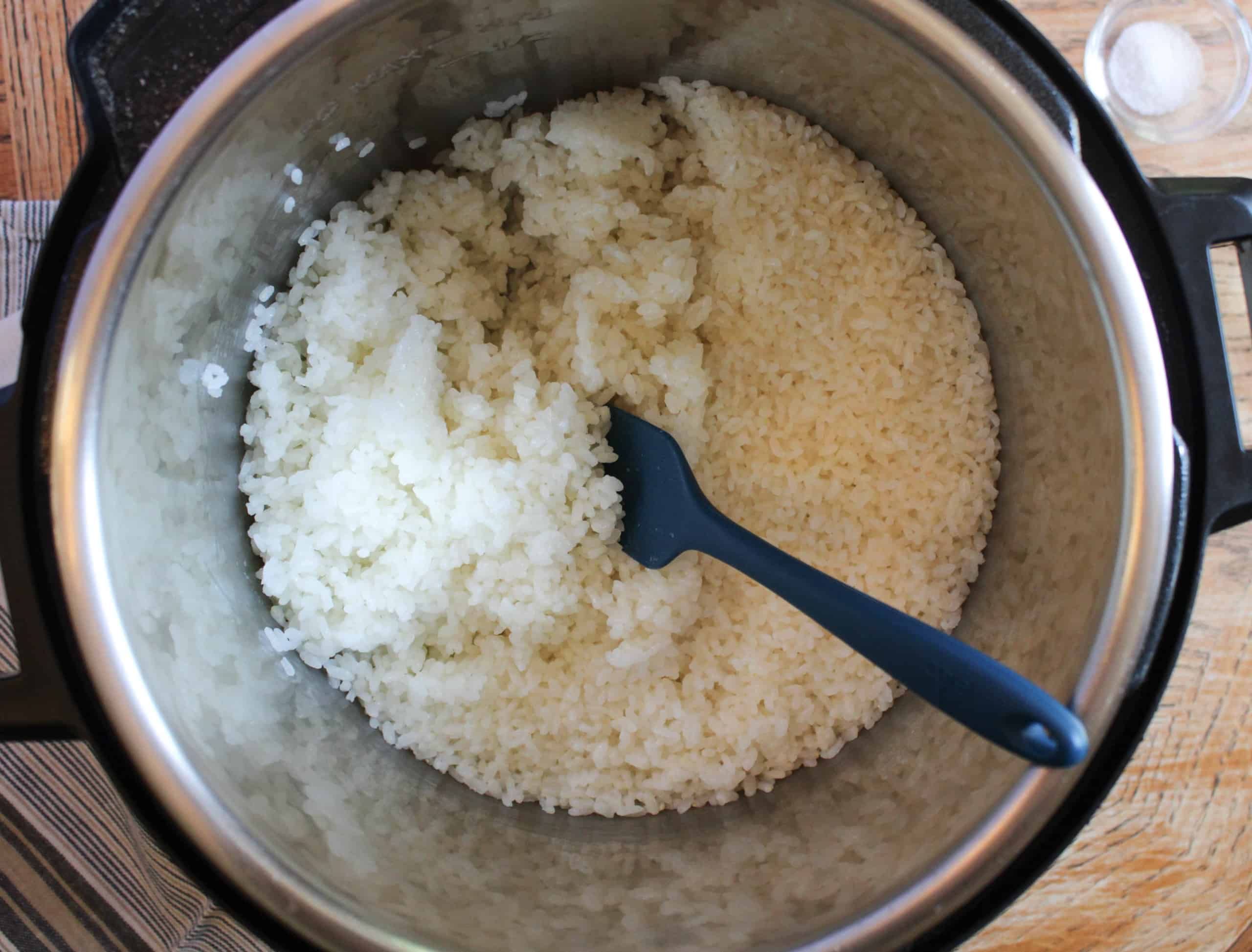 Rice in an instant pot with a silicon spatula.