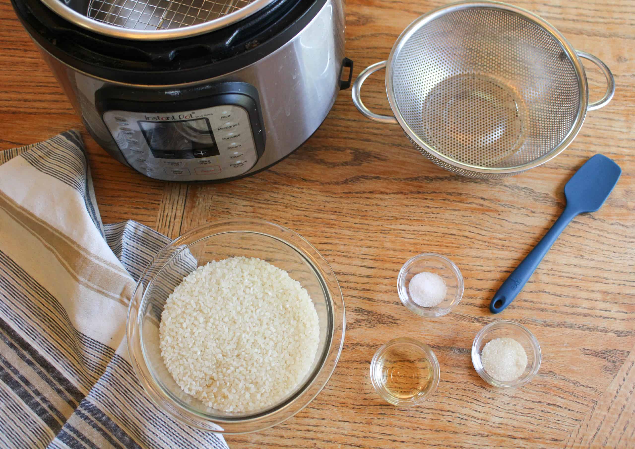 Ingredients for sushi rice sitting on a table with an instant pot.
