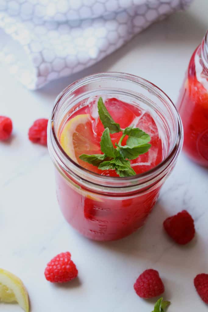 Overhead view of lemonade in a glass with a sprig of fresh mint. 