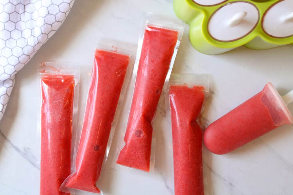 Strawberry lemonade ice pops on a table. 