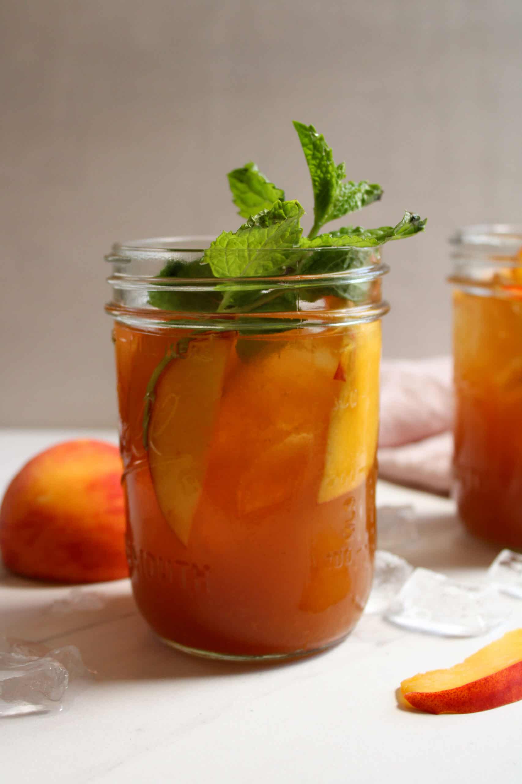 Iced peach sweet tea in a mason jar with ice.