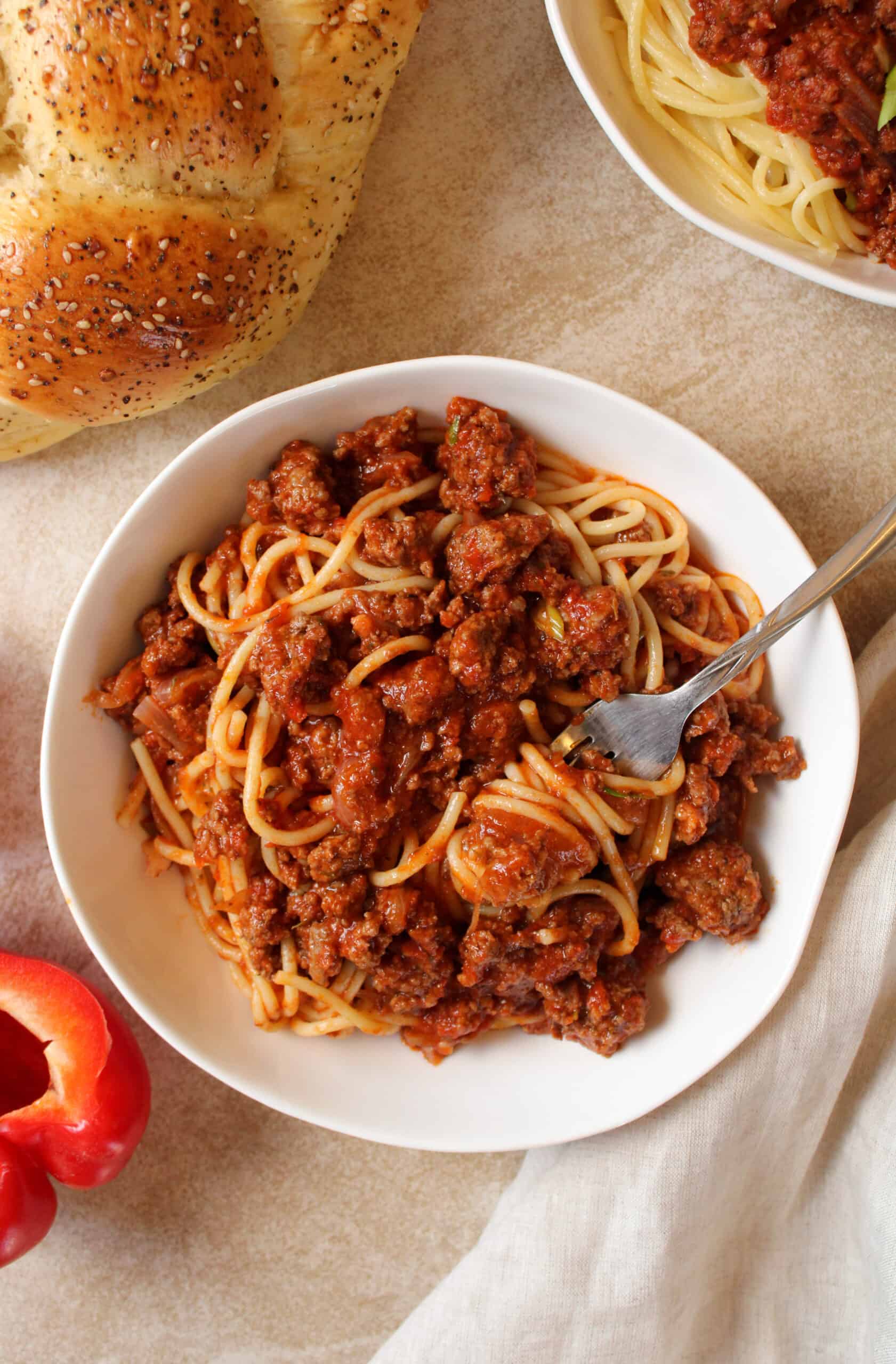 Bison Jollof Spaghetti in bowl with a fork.