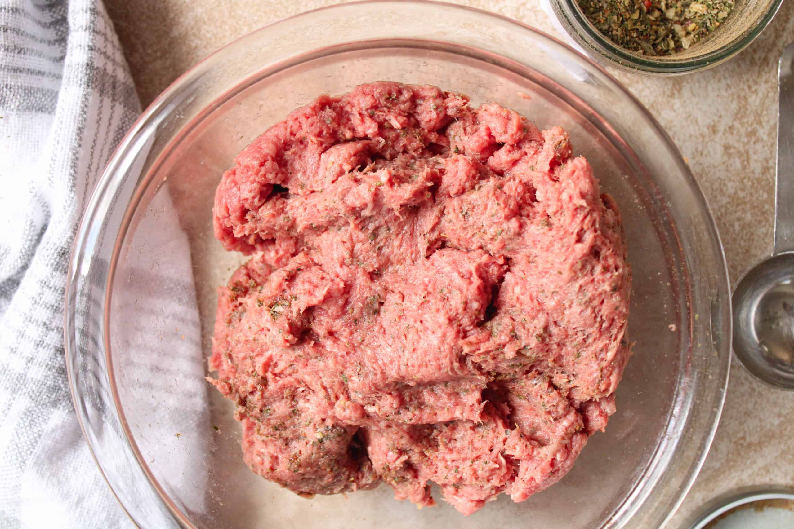 Ground beef mixed with breakfast sausage seasoning in a bowl. 