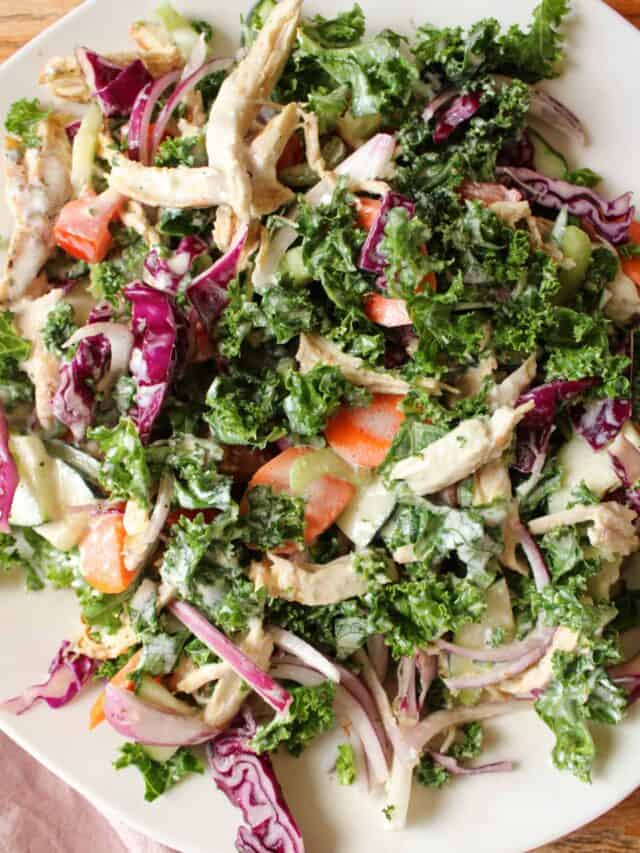 Close up on kale salad with shredded chicken.