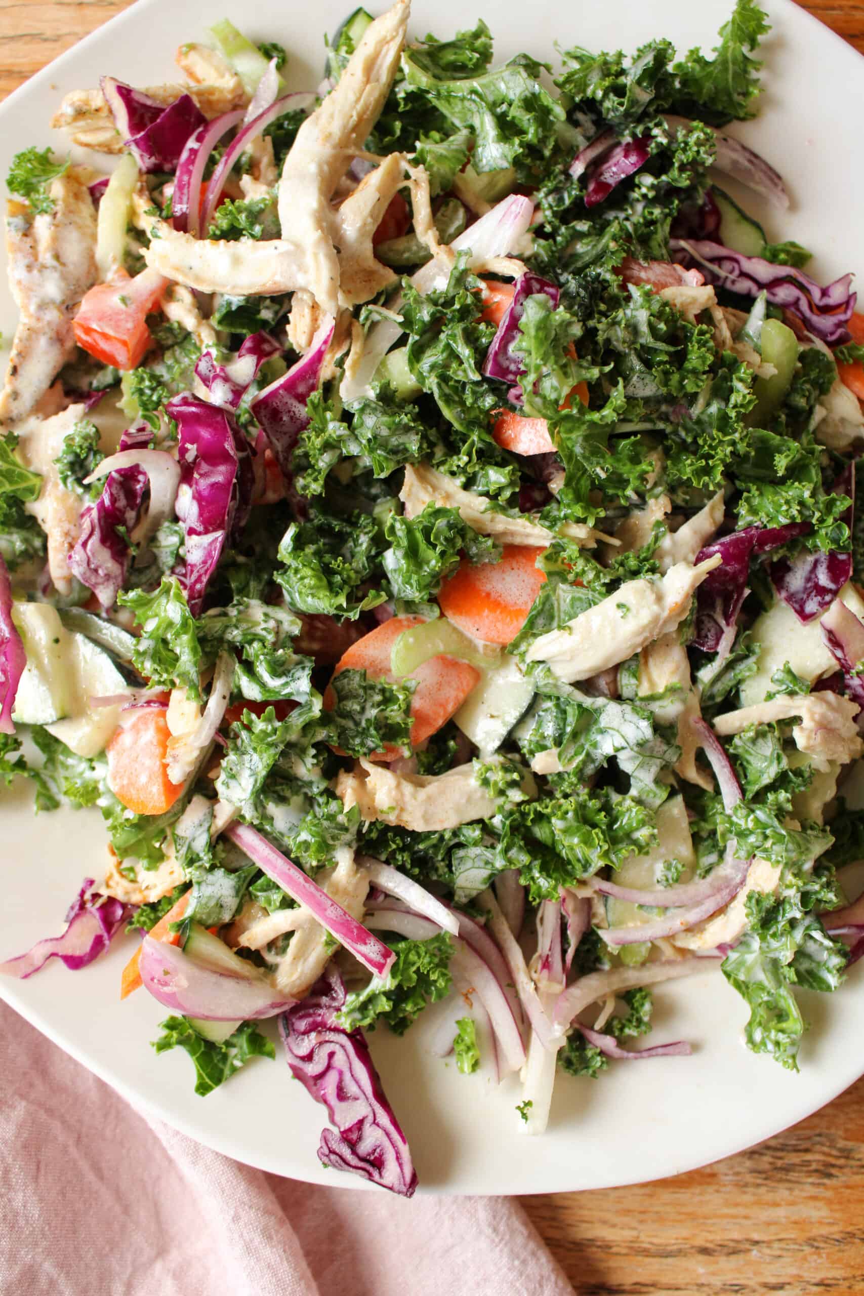 Close up on kale salad with shredded chicken.