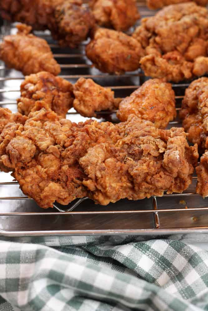 Side view of fried chicken without buttermilk on a wire rack. 