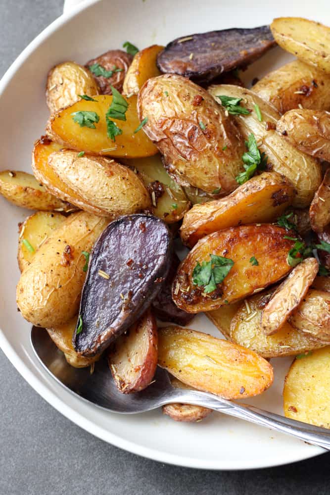Side view of roasted potatoes on a plate. 