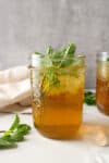 Side view of iced mint tea in a mason jar.
