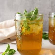 Side view of iced mint tea in a mason jar.