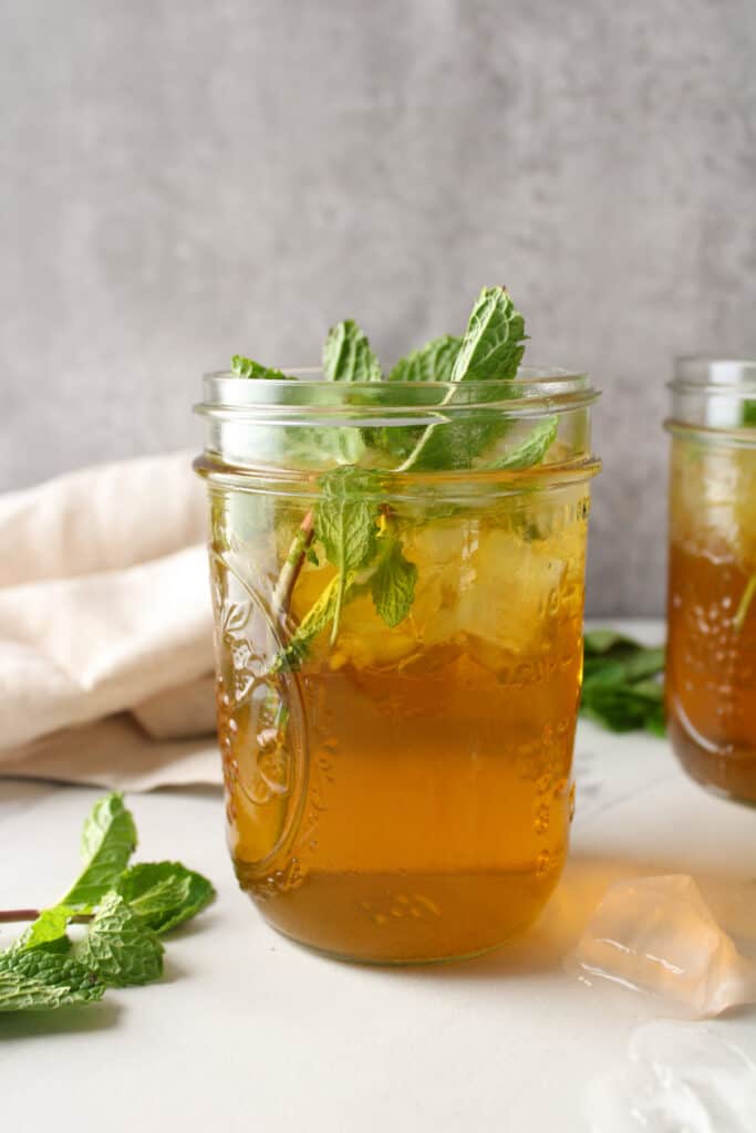Side view of iced mint tea in a mason jar. 