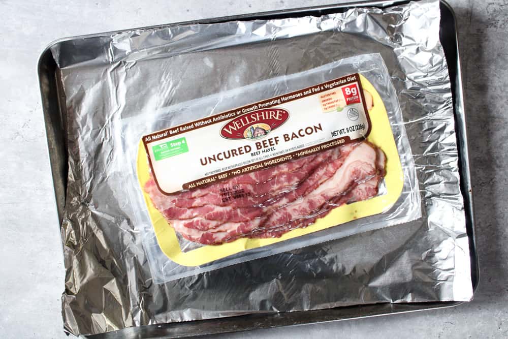 Package of beef bacon on a sheet pan.