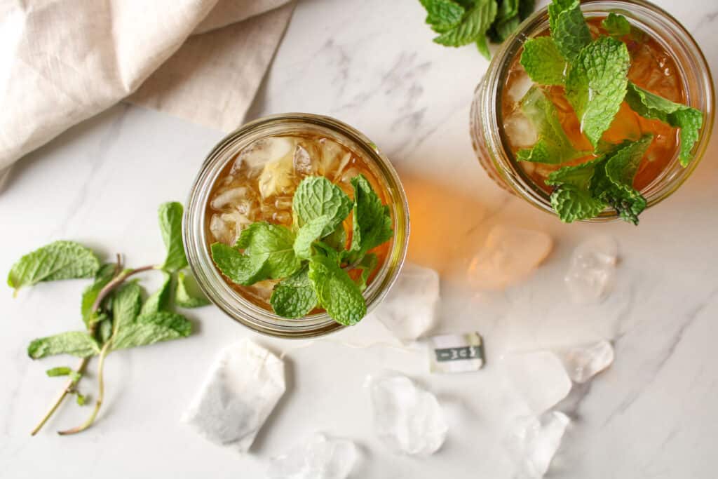 Overhead view of iced mint green tea on a counter with ice.