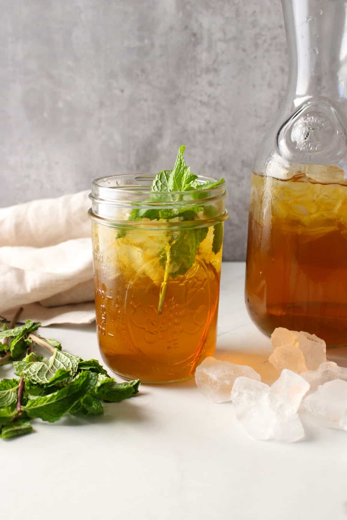 Side view of green tea with fresh mint in jars.