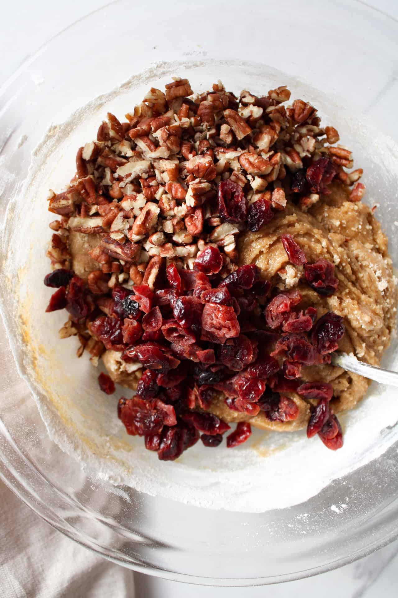 Brown butter cookies with dried cranberries and chopped pecans in a bowl.