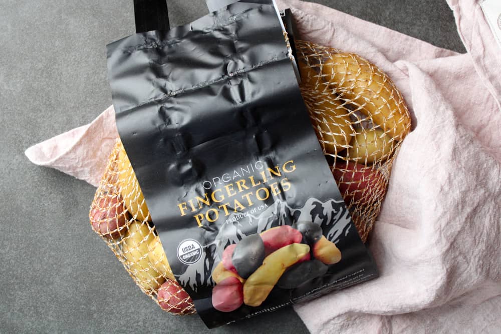 Fingerling potatoes in a mesh bag on a counter. 
