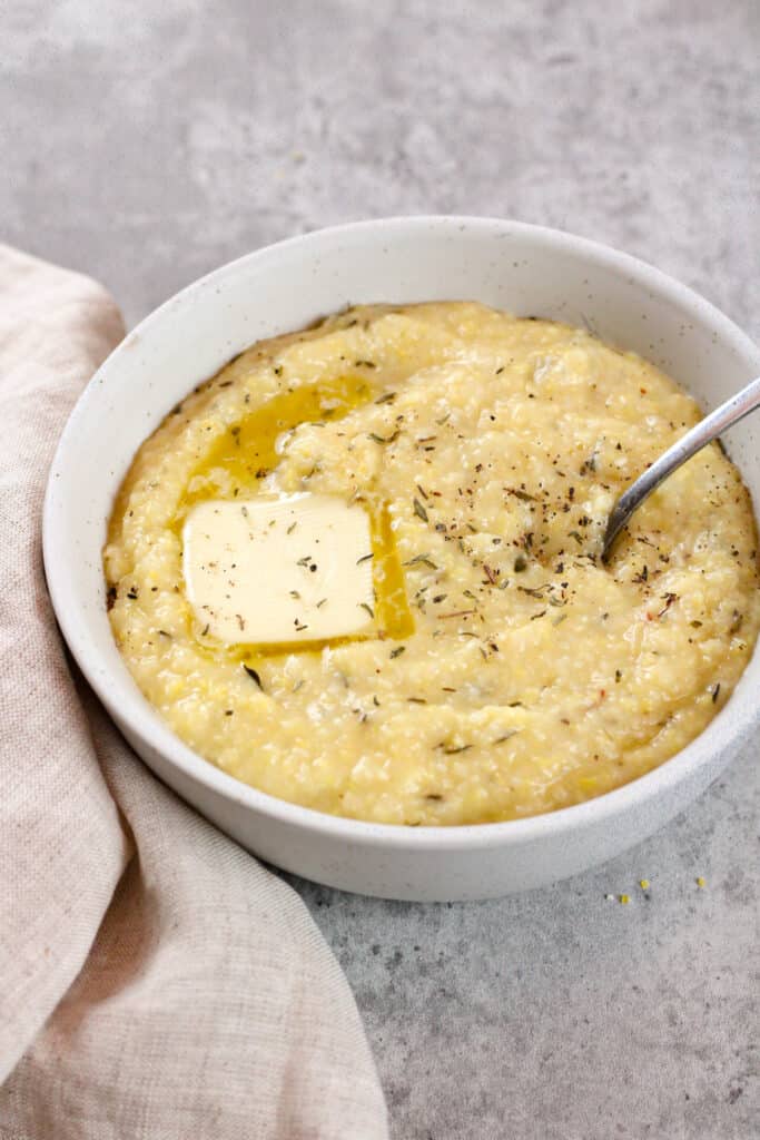 Close up on a bowl of creamy polenta with butter.