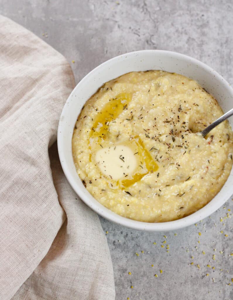 Creamy polenta in a bowl with melted butter.