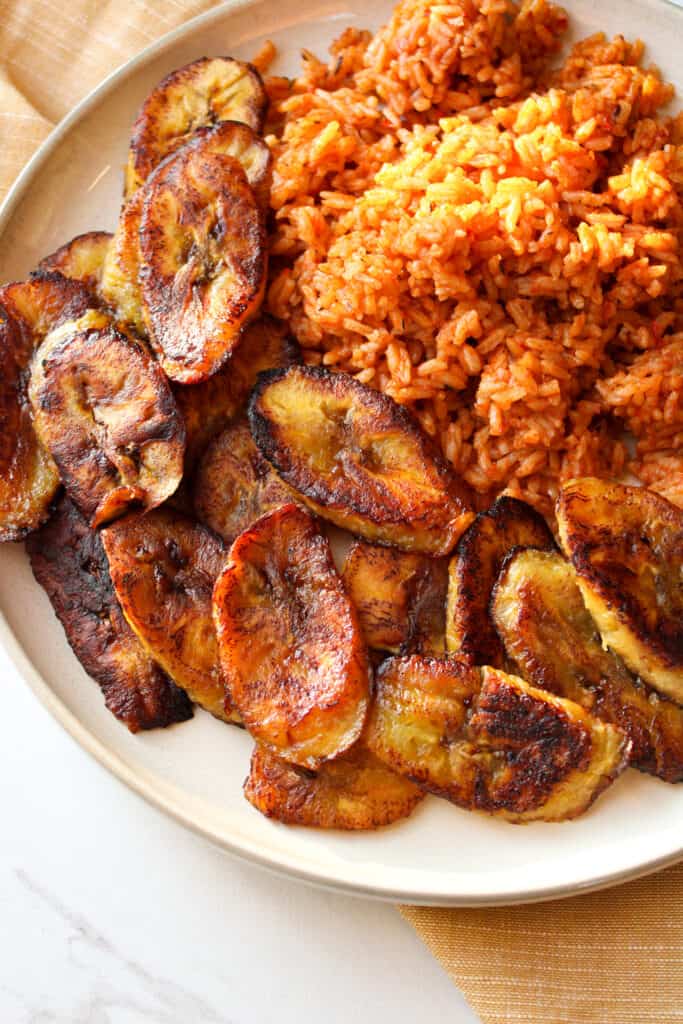 Close up on fried plantains with jollof rice.